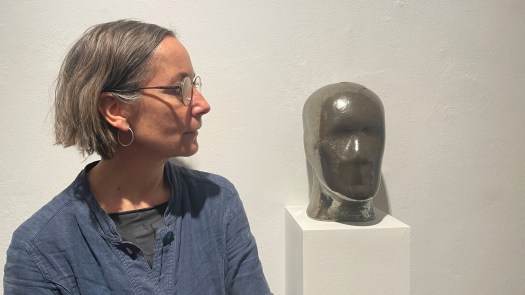 Ursula Kreutz mit massivem Keramikkopf. Immer wieder hat sie seine Konturen mit einem feuchten Tuch verwischt, um das Thema Auflösung darzustellen. 